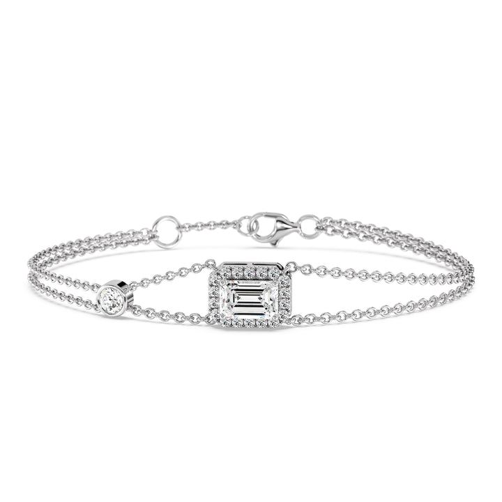 Stylish double-chain bracelet in 18K white gold, highlighted by a 1ct emerald-cut lab-grown diamond surrounded by a halo of 19 round EF/VS lab-grown diamonds.