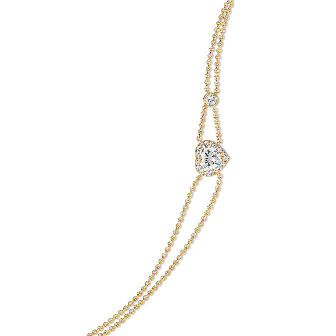 Double-chain bracelet in 18K yellow gold featuring a 1ct heart-cut lab-grown diamond surrounded by a halo of 19 round EF/VS lab-grown diamonds, showcasing timeless elegance and radiant sparkle