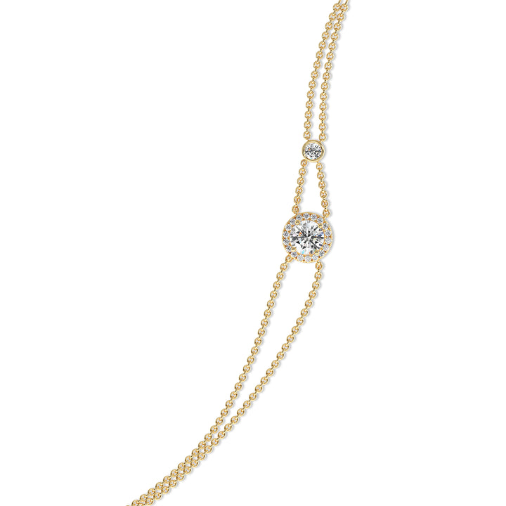 Image of the Halo-Set Round Lab-Grown Diamond Double Chain Bracelet in 18K Yellow Gold, featuring a 1ct round-cut lab-grown diamond surrounded by a halo of 19 smaller diamonds, with a unique double-chain design