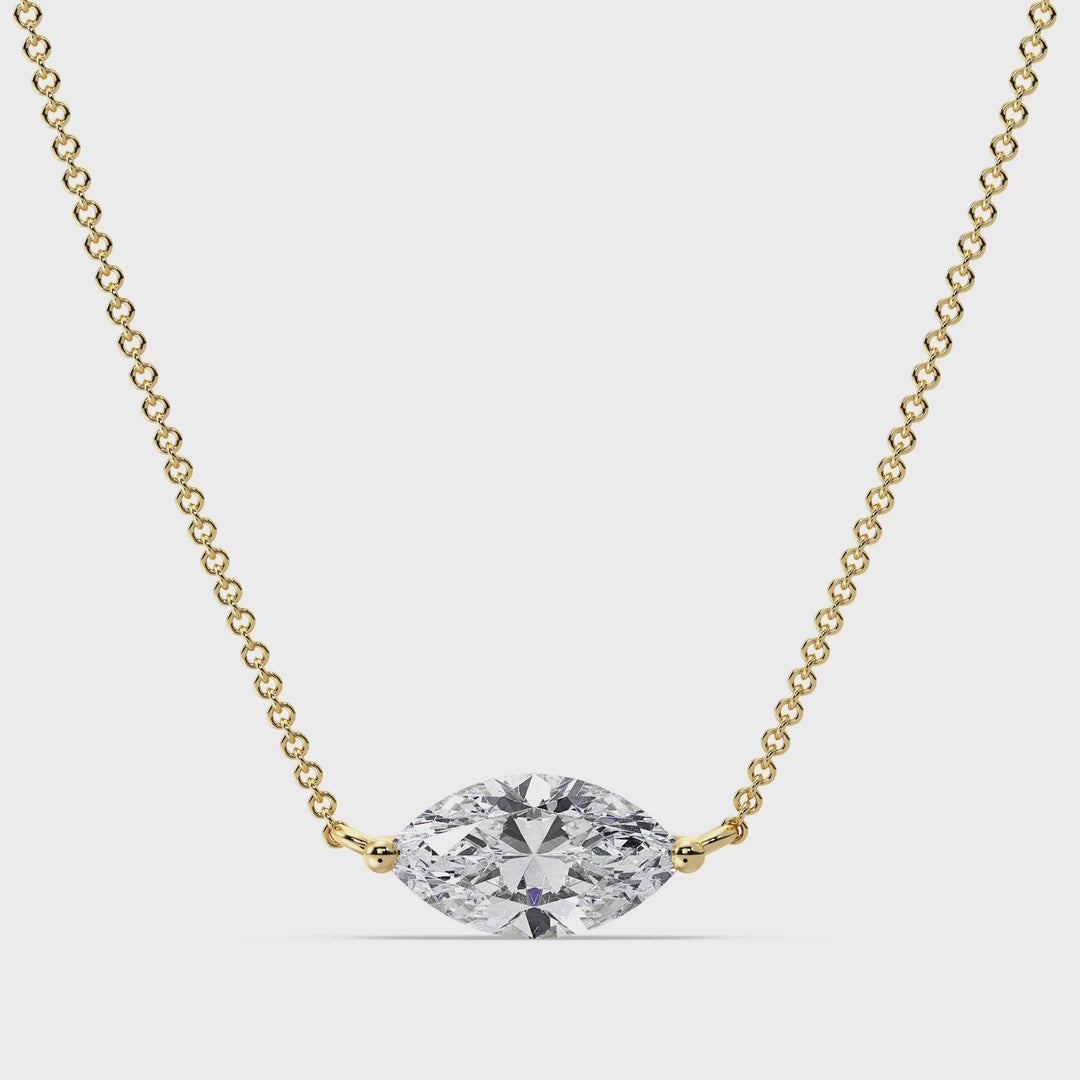 Close-up video showcasing the Yellow Gold variant of the 2.00 Carat Marquise-Cut Lab-Grown Diamond Solitaire Pendant Necklace. The sparkling IGI Certified E/VS diamond is elegantly set in a classic prong setting, suspended from a sleek 18K Yellow Gold chain. The video captures the diamond's brilliance and the luxurious shine of the yellow gold, highlighting the pendant's timeless beauty and craftsmanship