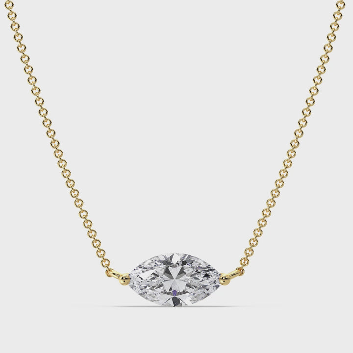 Close-up video showcasing the Yellow Gold variant of the 2.00 Carat Marquise-Cut Lab-Grown Diamond Solitaire Pendant Necklace. The sparkling IGI Certified E/VS diamond is elegantly set in a classic prong setting, suspended from a sleek 18K Yellow Gold chain. The video captures the diamond's brilliance and the luxurious shine of the yellow gold, highlighting the pendant's timeless beauty and craftsmanship