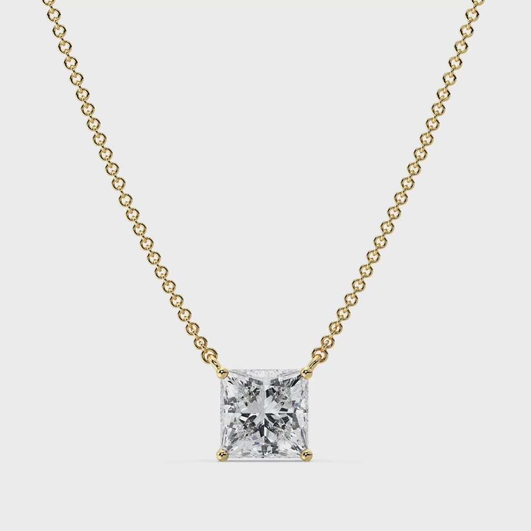 Close-up video showcasing a 2.00 Carat Princess Cut Lab-Grown Diamond Solitaire Pendant Necklace in 18K Yellow Gold. The sparkling IGI Certified E/VS diamond is set in a secure prong setting, suspended on a sleek yellow gold chain, catching the light with exceptional brilliance from every angle.