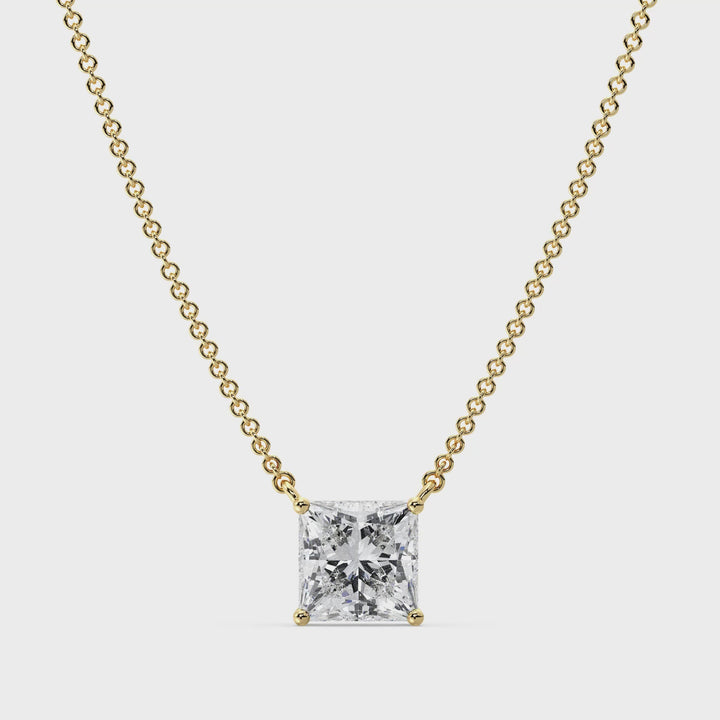 Close-up video showcasing a 2.00 Carat Princess Cut Lab-Grown Diamond Solitaire Pendant Necklace in 18K Yellow Gold. The sparkling IGI Certified E/VS diamond is set in a secure prong setting, suspended on a sleek yellow gold chain, catching the light with exceptional brilliance from every angle.