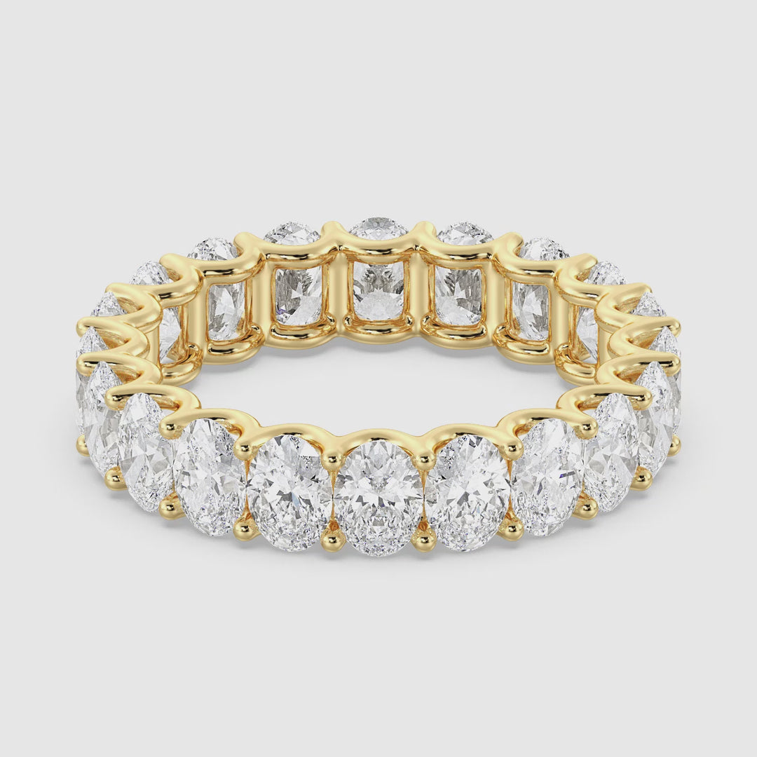A close-up video showcasing the Elegant Oval Lab-Grown Diamond Scallop Eternity Band in 18K Yellow Gold. The video highlights the brilliance of the 20 oval-shaped diamonds set in a shared prong design, with a delicate scalloped side profile for added elegance. The band is rotated to display the diamonds' sparkle from every angle, emphasizing the luxurious craftsmanship and radiant yellow gold finish