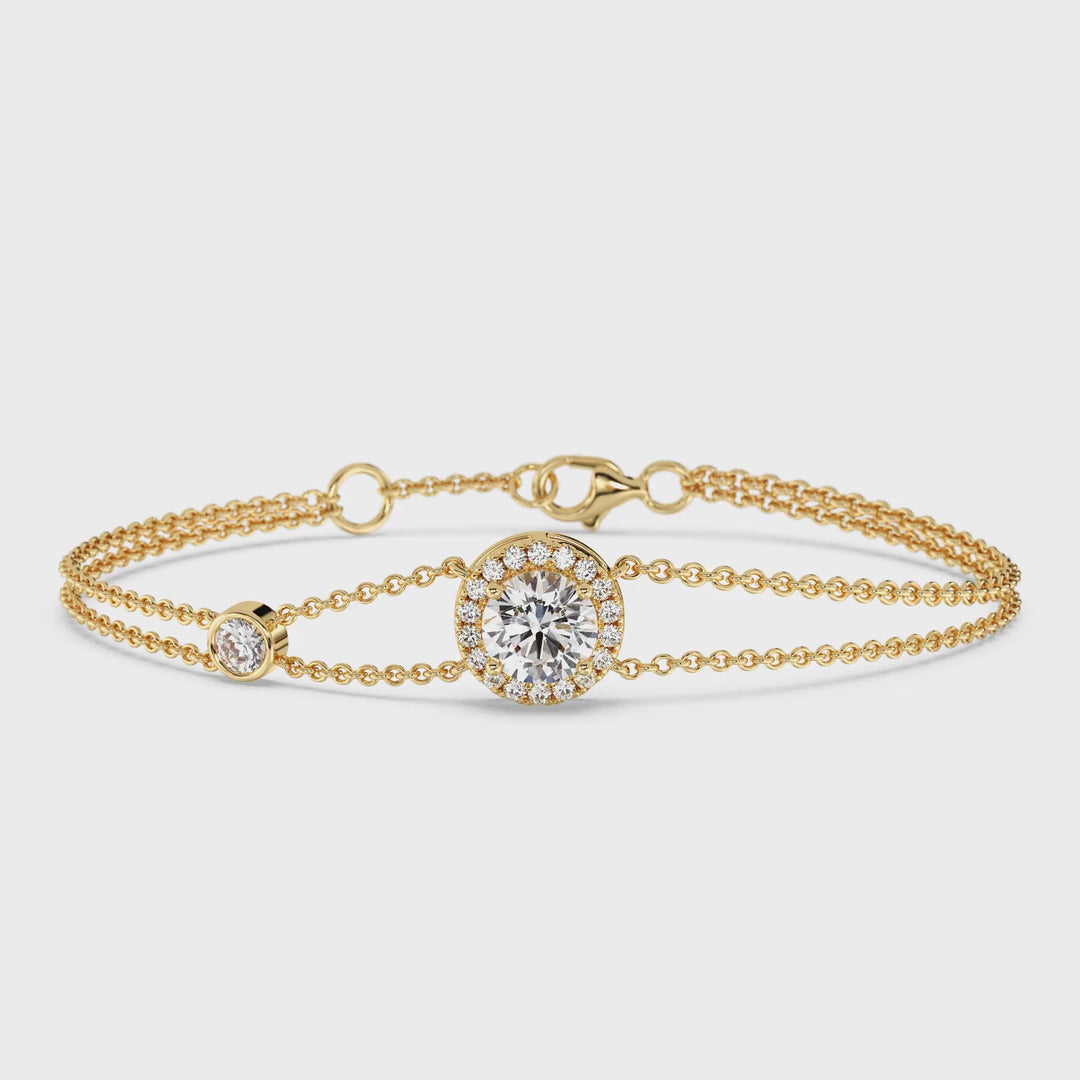 video showcasing the Yellow Gold variant of the Halo-Set Round Lab-Grown Diamond Double Chain Bracelet in 18K Gold. The bracelet features a sparkling 1ct round-cut lab-grown diamond at the center, surrounded by a halo of 19 smaller diamonds, all set in a luxurious 18K yellow gold design. The unique double-chain detail adds a modern touch to this timeless and elegant jewelry piece, with each diamond shimmering brilliantly under soft lighting