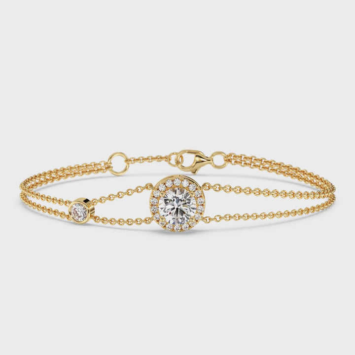 video showcasing the Yellow Gold variant of the Halo-Set Round Lab-Grown Diamond Double Chain Bracelet in 18K Gold. The bracelet features a sparkling 1ct round-cut lab-grown diamond at the center, surrounded by a halo of 19 smaller diamonds, all set in a luxurious 18K yellow gold design. The unique double-chain detail adds a modern touch to this timeless and elegant jewelry piece, with each diamond shimmering brilliantly under soft lighting